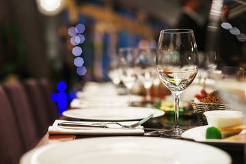 Glasses on the table during a party. Transparent clean glasses in neon light prepared for drinks. 