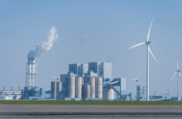 Fossil fuel (coal) power station and wind turbines in the Eemsharbor Eemshaven, Groningen, Holland.