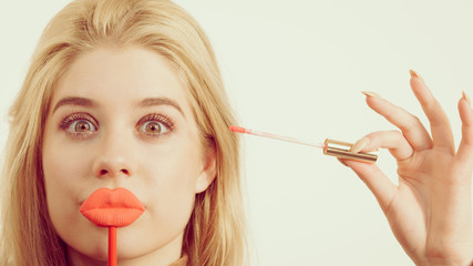 Woman applying lipstick or lip gloss