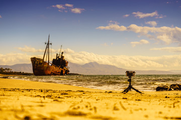 Camera on tripod and shipwreck