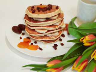 Stack of Pancakes on the Table with Tulips