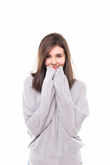 Smiling woman wearing in gray sweater standing against isolated gray background.