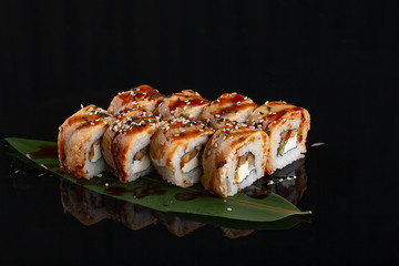 Tempura sushi with eel fish and cream cheese on black background