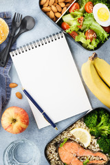 Healthy diet lunch boxes with food and empty notepad.