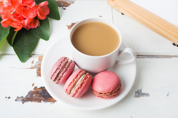 Cup of coffee and macaroon cookies on a plate on a white background. copy space