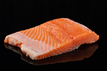 Raw salmon steak meat on black background