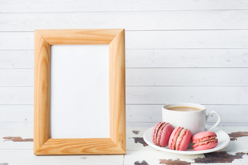 Fototapeta na wymiar Cup of coffee and macaroon cookies on a plate on a white background. copy space Blank text frame.
