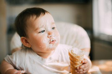 baby in the kitchen eagerly eating the delicious cream horns, filled with a vanilla cream