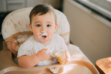 baby in the kitchen eagerly eating the delicious cream horns, filled with a vanilla cream