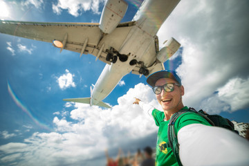 Huge plane over man's head during he taking selfie on the Maho beach