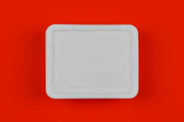 mock-up white plastic box on red background top view, disposable packaging for products. the concept of the problem of prohibiting the use of plastic packaging