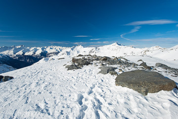 Fototapeta na wymiar Panoramic view down snow covered valley in alpine mountain range