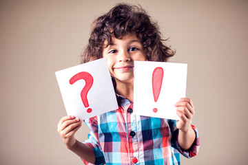 Thinking kid boy with question and exclamation signs - obrazy, fototapety, plakaty