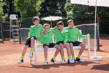 Group of young boys watching match on tennis court, Bavaria, Germany