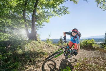 Mountain biker riding in forest, Bavaria, Germany