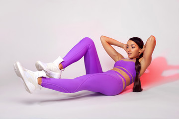 Obraz premium Strong athletic woman, doing exercise on white background wearing sportswear. Fitness and sport motivation.