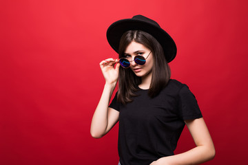 Young pretty woman in black rock style having fun over red background