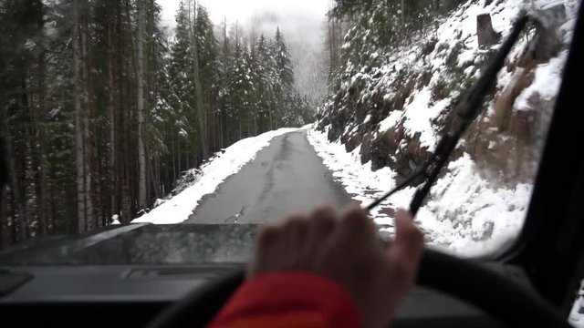 driving through the snowy mountains in the alps, in a landrover