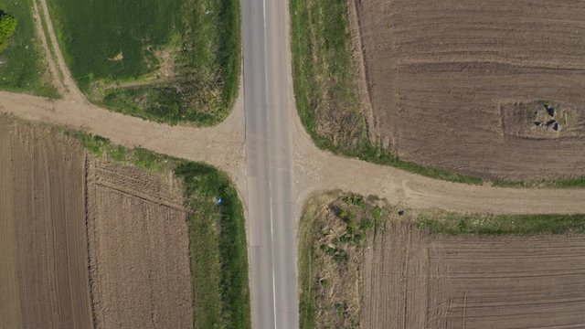 Aerial view of minibus on road, top down drone pov of vehicle driving through countryside