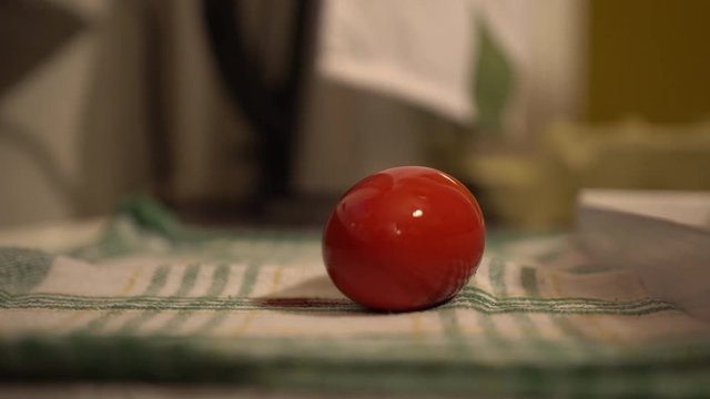 Putting colored eggs on a cloath on top of the table with a spoon. Closeup of an easter egg. Making easter eggs.
