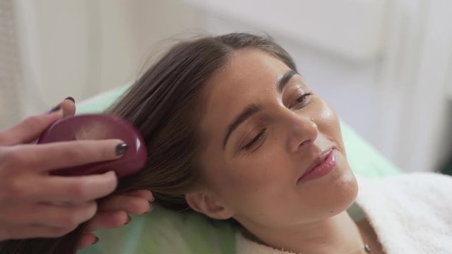 Young Caucasian Female Laying Down on Bed After Mesotherapy Treatment While Her Doctor Taking Care of Her Hair, Light Camera Movement