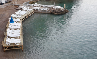 sunny deckchair on the beach in sea