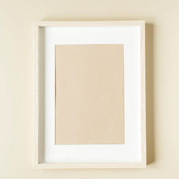 Minimal photo frame on beige wall. Modern interior design concept. Blank copy space mock up.