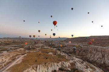 Hot air balloons flying over rock landscape at Cappadocia