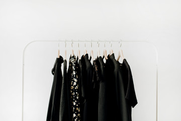 Minimal fashion clothes concept. Female blouses and t-shirts on hanger on white background. Fashion blog, website, social media hero header.