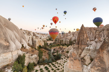 Fototapeta na wymiar Hot air balloons flying over rock landscape at Cappadocia