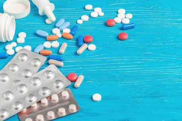 Many different pills on dark blue wooden background
