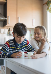 Happy children eating a yogurt.