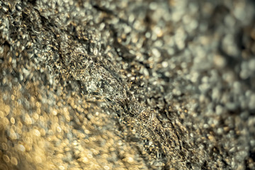 Background with blurry gradient of dark silver crumpled foil. Art photography. Toned image doesn’t in focus. Abstract blur pattern for poster, print. Macro. Soft focus.
