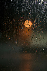Rain drops on the car glass in the night.