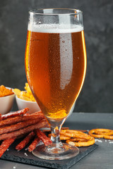  beer and appetizing beer snacks set. Table with mug of beer, wooden board with sausages