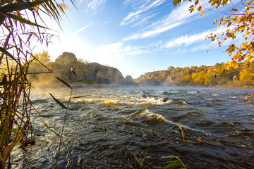 View on the cliff and water on a rapid mountain river in the early morning at autumn