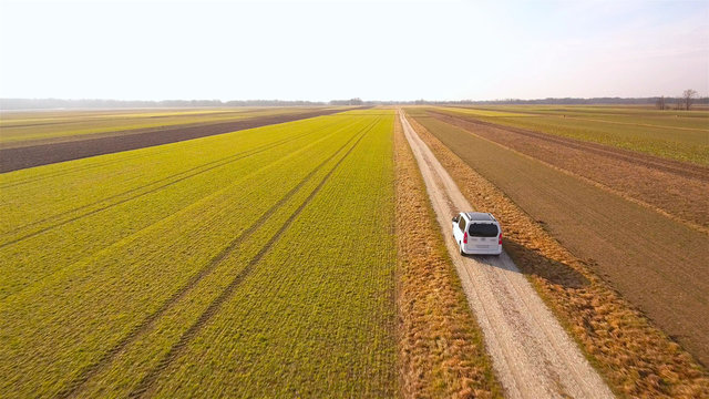 Flying behind a white van driving through farm fields © Video_StockOrg