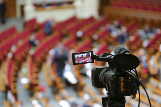 The camcorder stands on a tripod and removes the meeting room