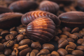  chocolate figures and coffee beans. chocolate and coffee. chocolate shells on a black background