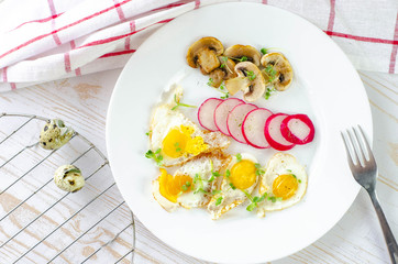 Healthy breakfast with quail eggs, radish, mushrooms and microgreens. Diet on a plate