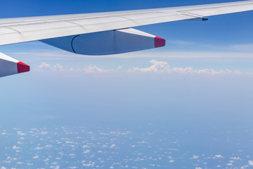 Naklejka na ściany i meble Airplane wing view out of the window the cloudy sky background, Travel and Holiday vacation concept