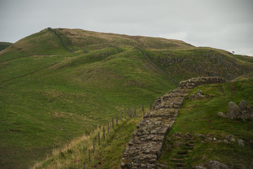 wall leading though hilly landscape