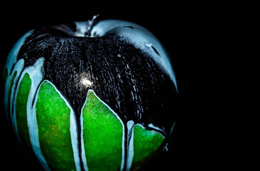 Green ripe apple with water droplets on a dark background, closeup