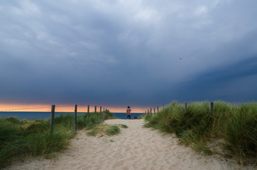 woman standing on a sand dune at the oceanfront