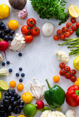 Top view flat lay with various vegetables on concrete background. Enoki mushrooms, asparagus, cherry tomatoes and berries. Summer food ingredients concept