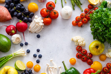 Top view flat lay with various vegetables on concrete background. Enoki mushrooms, asparagus, cherry tomatoes and berries. Summer food ingredients concept
