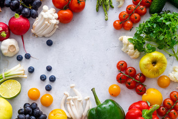Top view flat lay with various vegetables on concrete background. Enoki mushrooms, asparagus, cherry tomatoes and berries. Summer food ingredients concept