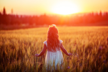 Little girl in white dress in field