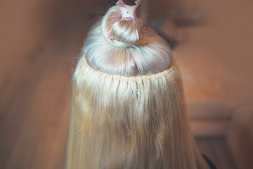 hair extension on tress in Hollywood way, African style, master in the process of work step by step