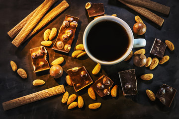 black coffee, chocolate, almonds, cookies. on a dark wooden background.